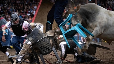 Inmates participate in Convict Poker where they aim to be the last contestant with their hands on the table as a bull charges them during the Angola Prison Rodeo. The rodeo, described on its website as the "wildest show in the south," features about a dozen events in which prisoners and professional cowboys compete under the watchful eyes of prison guards and the viewing public. (Brendan Smialowski / AFP) Inmates participate in Convict Poker where they aim to be the last contestant with their hands on the table as a bull charges them during the Angola Prison Rodeo. The rodeo, described on its website as the "wildest show in the south," features about a dozen events in which prisoners and professional cowboys compete under the watchful eyes of prison guards and the viewing public. (Brendan Smialowski / AFP)