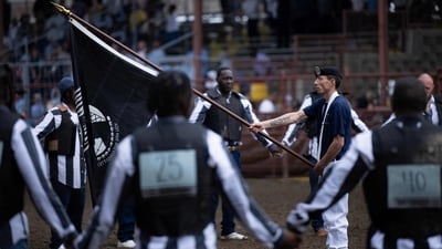 Inmates participate in a starting ceremony during the Angola Prison Rodeo. In the dirt-floored arena, inmates in striped uniforms, helmets, and cowboy hats walk around freely and prepare for their upcoming shows, reported AFP. (Brendan Smialowski / AFP) Inmates participate in a starting ceremony during the Angola Prison Rodeo. In the dirt-floored arena, inmates in striped uniforms, helmets, and cowboy hats walk around freely and prepare for their upcoming shows, reported AFP. (Brendan Smialowski / AFP)