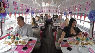 Tourists sit on a Coronation Tour Bus, in London. The May 6 coronation is luring royal fans and far-flung visitors fascinated by the ceremonial spectacle — and drama — of the monarchy and eager to experience a piece of British history. Tour companies, shops and restaurants are rolling out the red carpet, whether it's a decked-out bus tour of London's top sights boasting high tea or merchandise running from regal to kitschy. (AP Photo/Kin Cheung) Tourists sit on a Coronation Tour Bus, in London. The May 6 coronation is luring royal fans and far-flung visitors fascinated by the ceremonial spectacle — and drama — of the monarchy and eager to experience a piece of British history. Tour companies, shops and restaurants are rolling out the red carpet, whether it's a decked-out bus tour of London's top sights boasting high tea or merchandise running from regal to kitschy. (AP Photo/Kin Cheung)