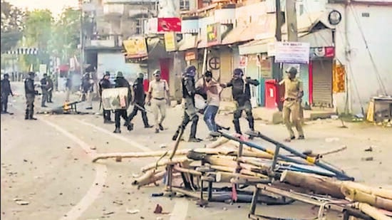 Security personnel detain people while trying to control the situation after violent protests over the death of a minor girl in North Dinajpur district, West Bengal, on Tuesday. (PTI)