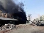 This handout photo shows smoke rising from a building next to a damaged car on a street in Khartoum.