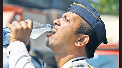 Mumbai, India - April 18, 2023: A traffic constable satiates his thirst by drinking bottled water during the heatwave in the city, at Sion, in Mumbai, India, on Tuesday, April 18, 2023. (Photo by Vijay Bate/HT Photo) (HT PHOTO)