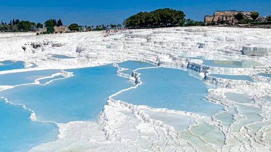Pamukkale, Turkey: These hot springs have created terraces of white mineral deposits, giving the landscape a snowy appearance.&nbsp;(Unsplash)