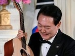 South Korea's President Yoon Suk Yeol looks at a guitar. South Korea's President Yoon Suk Yeol looks at a guitar.