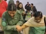 Woman IAF officer lending a helping hand to a female passenger during Operation Kaveri. 