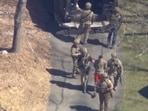 Jack Teixeira, in T-shirt and shorts, being taken into custody by armed tactical agents on Thursday, April 13. 