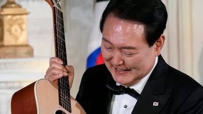 South Korea's President Yoon Suk Yeol looks at a guitar. (AP)