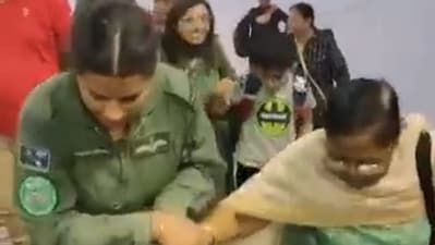 Woman IAF officer lending a helping hand to a female passenger during Operation Kaveri. (ANI)