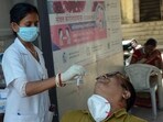 A healthcare worker collects a nasal swab sample of a person for COVID-19 testing in view of the rising Coronavirus cases.