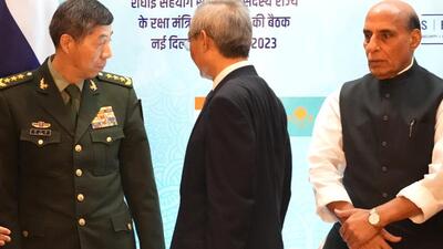 Chinese Defence Minister General Li Shangfu, left, talks to his Indian counterpart Rajnath Singh, right, before the start of defence ministers meeting of Shanghai Cooperation Organisation (SCO) summit, in New Delhi on Friday (AP)