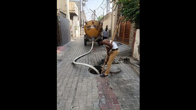 Sanitation workers cleaning a drain in Bathinda on Friday. (Photo by Sanjeev Kumar/Hindustan Times)