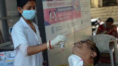 A healthcare worker collects a nasal swab sample of a person for COVID-19 testing in view of the rising Coronavirus cases. (ANI)