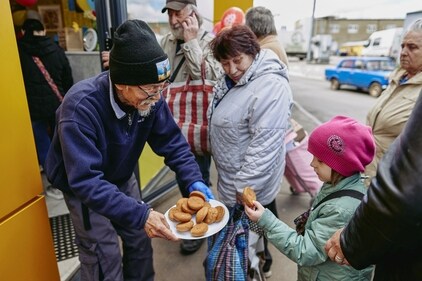 Fuminori Tsuchiko treats a girl with cookies outside of his cafe. (REUTERS)