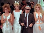 German designer Karl Lagerfeld joins models, from left, American Cindy Crawford, Canadian Linda Evangelista and Claudia Schiffer of Germany after the presentation of his 1996 spring-summer ready-to-wear fashion collection for Chanel in Paris on Oct. 19, 1995. Lagerfeld died in 2019 after dominating the fashion universe into his 80s.
