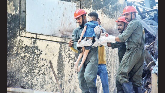 A child is taken for treatment after rescue teams pulled him out of debris by rescue teams after a three-storeyed building collapsed in Bhiwandi on Saturday. (PRAFUL GANGURDE / HT PHOTO)