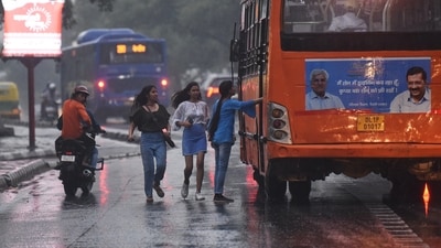 Women trying to catch a bus during rainfall, in New Delhi on Sunday. (ANI photo) Women trying to catch a bus during rainfall, in New Delhi on Sunday. (ANI photo)