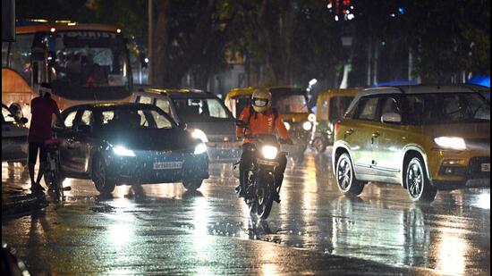Commuters caught in rain at Connaught Place in New Delhi on Sunday. (Sanjeev Verma/HT Photo)