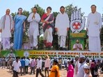 Congress supporters walk past giant cut-outs of senior party leaders in Karnataka’s Kolar. (PTI)