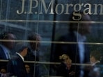 Workers are reflected in the windows of the Canary Wharf offices of JP Morgan in London.
