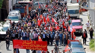 Supporters of the Lebanese Communist Party and members of the labour syndicate march in Beirut to mark the International Workers' Day. (AFP) Supporters of the Lebanese Communist Party and members of the labour syndicate march in Beirut to mark the International Workers' Day. (AFP)