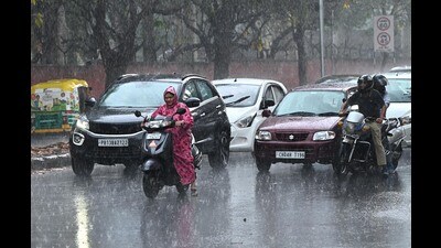 Commuters caught in the rain in Chandigarh on Monday. (Keshav Singh/HT)
