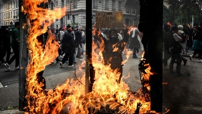 A protestor holds a sign reading "Shoked by burnt plastic but not by our stolen pensions" during a demonstration on May Day (Labour Day) to mark the international day of the workers in France. (AFP)
