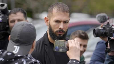 Andrew Tate looks at a man filming with a mobile phone as he leaves the Bucharest Tribunal, in Bucharest, Romania, (AP) Andrew Tate looks at a man filming with a mobile phone as he leaves the Bucharest Tribunal, in Bucharest, Romania, (AP)