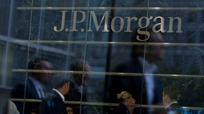 Workers are reflected in the windows of the Canary Wharf offices of JP Morgan in London. (Reuters)