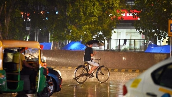 Commuters out during rain at Connaught Place, in New Delhi. (Sanjeev Verma/HT) (File) (HT_PRINT)