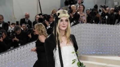 Elle Fanning picked a sleek white gown decorated in white lace details and a black velvet jacket as she accessorised her look a white flower headgear and a matching flower bouquet. (AP) Elle Fanning picked a sleek white gown decorated in white lace details and a black velvet jacket as she accessorised her look a white flower headgear and a matching flower bouquet. (AP)