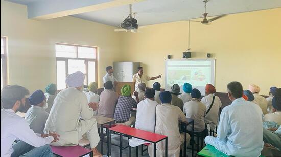 The officials and employees of the water resources department organising awareness camp to encourage farmers to use canal water for irrigation purposes. (HT Photo)