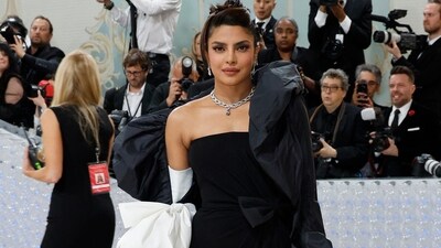 Priyanka's strapless, black dress was simple with a floor-length skirt and thigh-high slit. But her textured black cape was adorned with an oversized bow that matched her white gloves. (AFP) Priyanka's strapless, black dress was simple with a floor-length skirt and thigh-high slit. But her textured black cape was adorned with an oversized bow that matched her white gloves. (AFP)