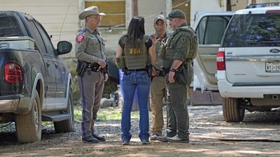 Law enforcement officials in the neighborhood where a mass shooting occurred in Texas. (AP)