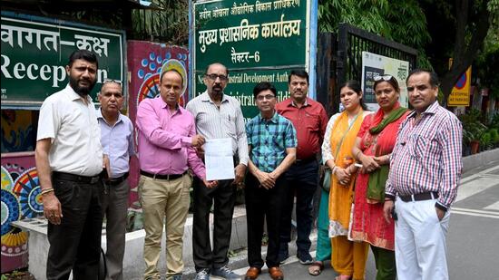 Parents of students at Uttarakhand Public School with the Noida authority order. (Sunil Ghosh/HT Photo)