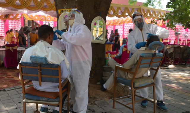 Flashback to a frightening time: Barbers in PPE kits attending to customers in Panchkula, Punjab, on June 01, 2020 (Sant Arora/Hindustan Times) Flashback to a frightening time: Barbers in PPE kits attending to customers in Panchkula, Punjab, on June 01, 2020 (Sant Arora/Hindustan Times)