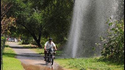 A biker crossing near the water leakage in sector 47, Chandigarh. (Ravi Kumar/HT) A biker crossing near the water leakage in sector 47, Chandigarh. (Ravi Kumar/HT)