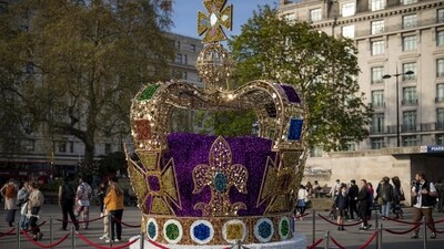 King Charles Coronation: People walk by an art installation depicting the St Edward's crown in central London. (AP) King Charles Coronation: People walk by an art installation depicting the St Edward's crown in central London. (AP)