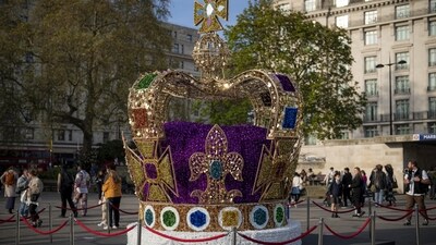 King Charles Coronation: People walk by an art installation depicting the St Edward's crown in central London. (AP) King Charles Coronation: People walk by an art installation depicting the St Edward's crown in central London. (AP)