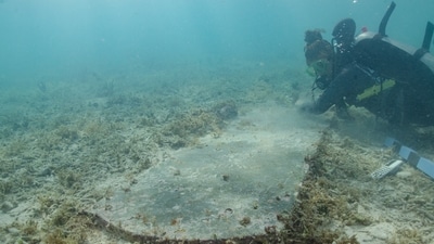 University of Miami graduate student Devon Fogarty examines the headstone of John Greer who died while working at Fort Jefferson on Nov. 5, 1861. The gravesite is now completely underwater. (NPS) University of Miami graduate student Devon Fogarty examines the headstone of John Greer who died while working at Fort Jefferson on Nov. 5, 1861. The gravesite is now completely underwater. (NPS)