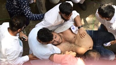 An NCP worker is being rescued as he tried to die by suicide outside the party office in Mumbai. (Anshuman Poyrekar/HT) An NCP worker is being rescued as he tried to die by suicide outside the party office in Mumbai. (Anshuman Poyrekar/HT)