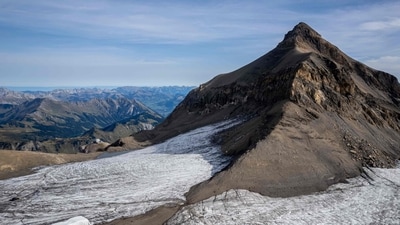 This aerial picture taken on September 13, 2022 at Glacier 3000 resort above Les Diablerets shows the Tsanfleuron pass free of the ice that covered it for at least 2,000 years next to blankets (L) covering snow from the last winter season to prevent it from melting. (AFP) This aerial picture taken on September 13, 2022 at Glacier 3000 resort above Les Diablerets shows the Tsanfleuron pass free of the ice that covered it for at least 2,000 years next to blankets (L) covering snow from the last winter season to prevent it from melting. (AFP)