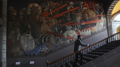 Historian Jonatan Chavez ascends a flight of stairs past a mural by Jean Charlot titled, “Massacre en el Templo Mayor”, illustrating the 1521 massacre that the Spaniards led in the most sacred site of the Aztec empire, at the former Jesuit college Antiguo Colegio de San Ildefonso in Mexico City, Wednesday, April 26, 2023. (AP Photo/Marco Ugarte) (AP) Historian Jonatan Chavez ascends a flight of stairs past a mural by Jean Charlot titled, “Massacre en el Templo Mayor”, illustrating the 1521 massacre that the Spaniards led in the most sacred site of the Aztec empire, at the former Jesuit college Antiguo Colegio de San Ildefonso in Mexico City, Wednesday, April 26, 2023. (AP Photo/Marco Ugarte) (AP)