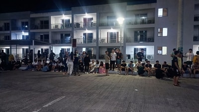 Rescued trafficked people from Asian countries standing outside a building after a police raid inside a freeport zone in Mabalacat City, in Pampanga province, north of Manila. (AFP) Rescued trafficked people from Asian countries standing outside a building after a police raid inside a freeport zone in Mabalacat City, in Pampanga province, north of Manila. (AFP)