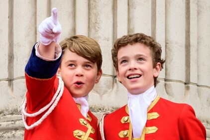 Prince George (L) points while on the balcony of Buckingham Palace during the Coronation of King Charles III and Queen Camilla. (Reuters)