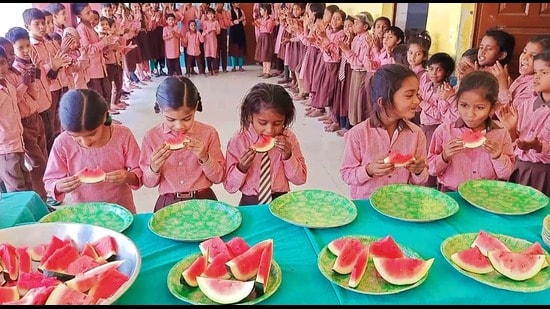 Students of Composite Vidyalaya, Mahpur, Mau, gorgin on watermelon (HT Photo)