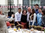 Britain's Prime Minister Rishi Sunak (rear L) poses for pictures with guests during a Coronation Big Lunch organised in Downing Street, in London, on May 7. Britain's Prime Minister Rishi Sunak (rear L) poses for pictures with guests during a Coronation Big Lunch organised in Downing Street, in London, on May 7.
