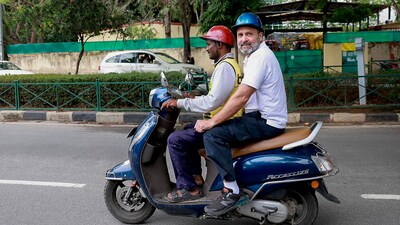 Congress leader Rahul Gandhi rides a scooter with a food delivery man, during his election campaign in Bengaluru, Karnataka. (PTI)