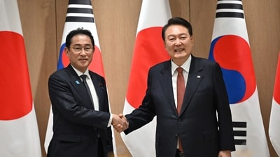 South Korean President Yoon Suk Yeol (R) shakes hands with Japanese Prime Minister Fumio Kishida. (AFP)