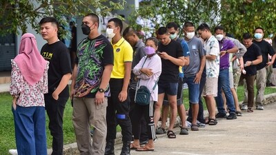 Voters wait in line to cast their ballot during advance voting at a polling station in a school in Narathiwat, southern Thailand. (AFP)
