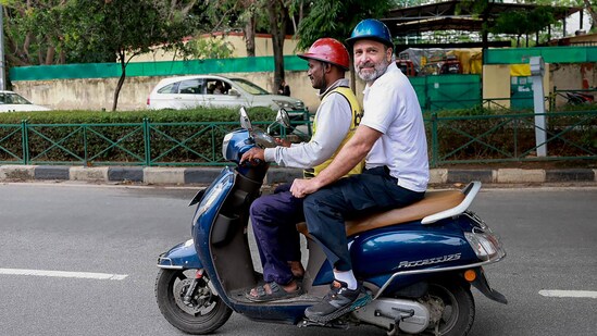Congress leader Rahul Gandhi rides a scooter with a food delivery man, during his election campaign in Bengaluru, Karnataka.(PTI)